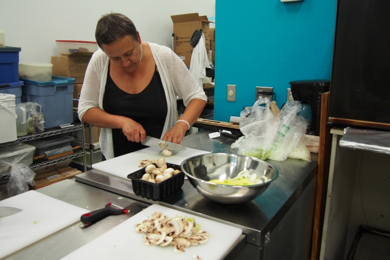 Cauldron Food School student slicing mushrooms.
